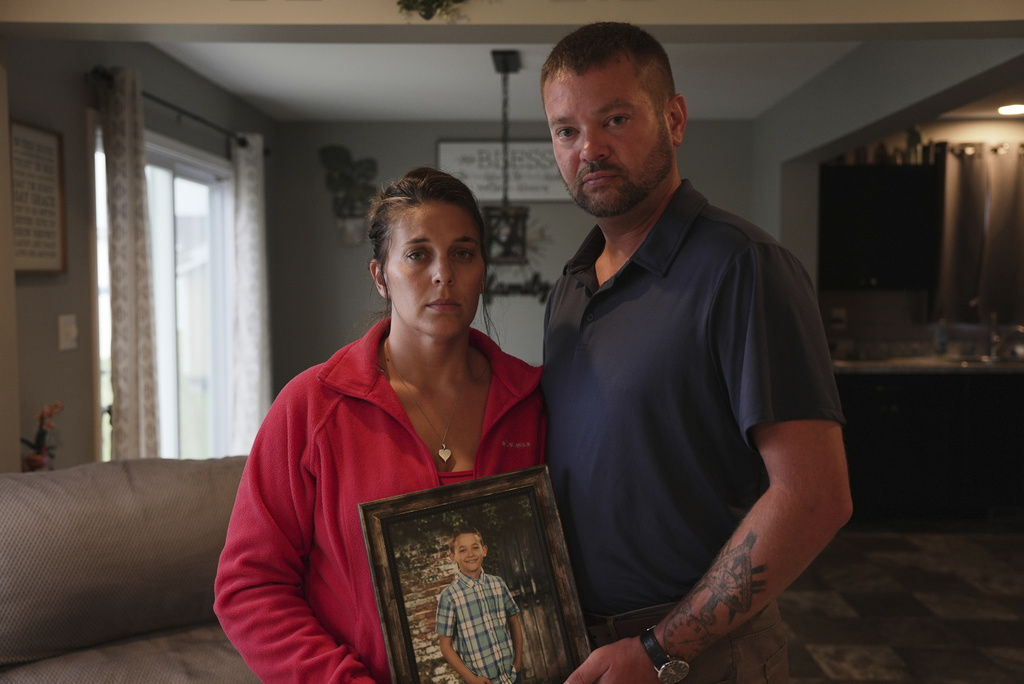 Ashlee and Erik Dahlberg hold a photo of their late son, Liam, in their home in Lowell, Ind., on Tuesday, Aug. 12, 2025. (AP Photo/Laura Bargfeld)