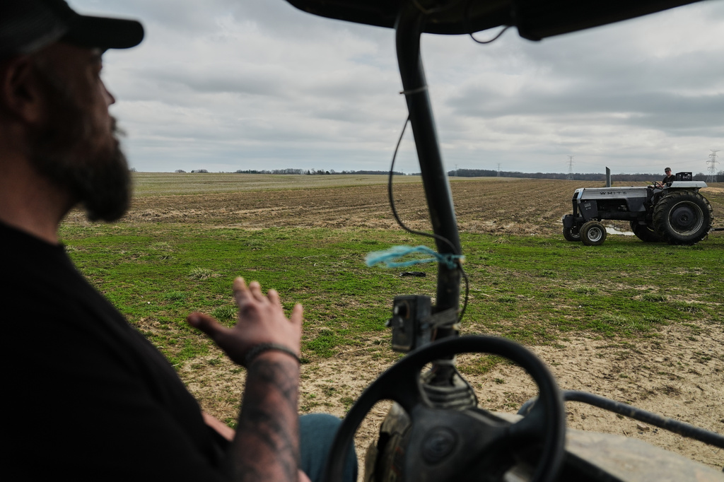 Wayne Greier, left, talks with his son, Blake, 13, right, as they move farm equipment Tuesday, March 10, 2026, in Canfield, Ohio. (AP Photo/Joshua A. Bickel)
