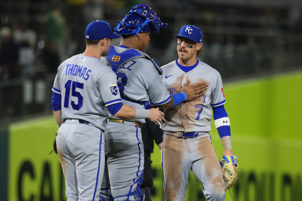 Kansas City Royals' Bobby Witt Jr. (7) and Salvador Perez, middle, celebrate the Royals victory over the Athletics in a baseball game Tuesday, April 28, 2026, in West Sacramento, Calif. (AP Photo/Scott Marshall)