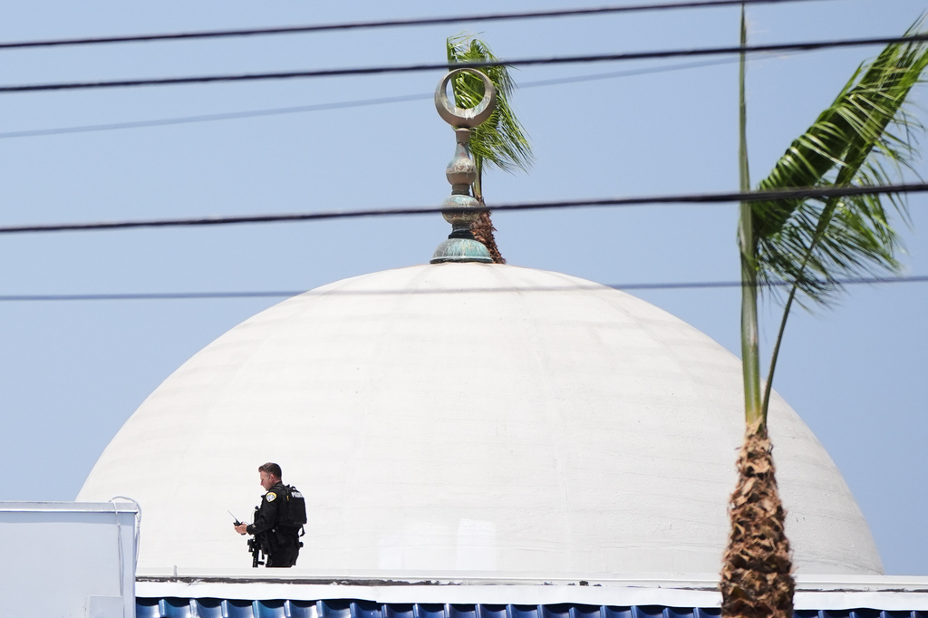 Police stage on a roof at the scene of a shooting outside the Islamic Center of San Diego Monday, May 18, 2026, in San Diego. (AP Photo/Gregory Bull)