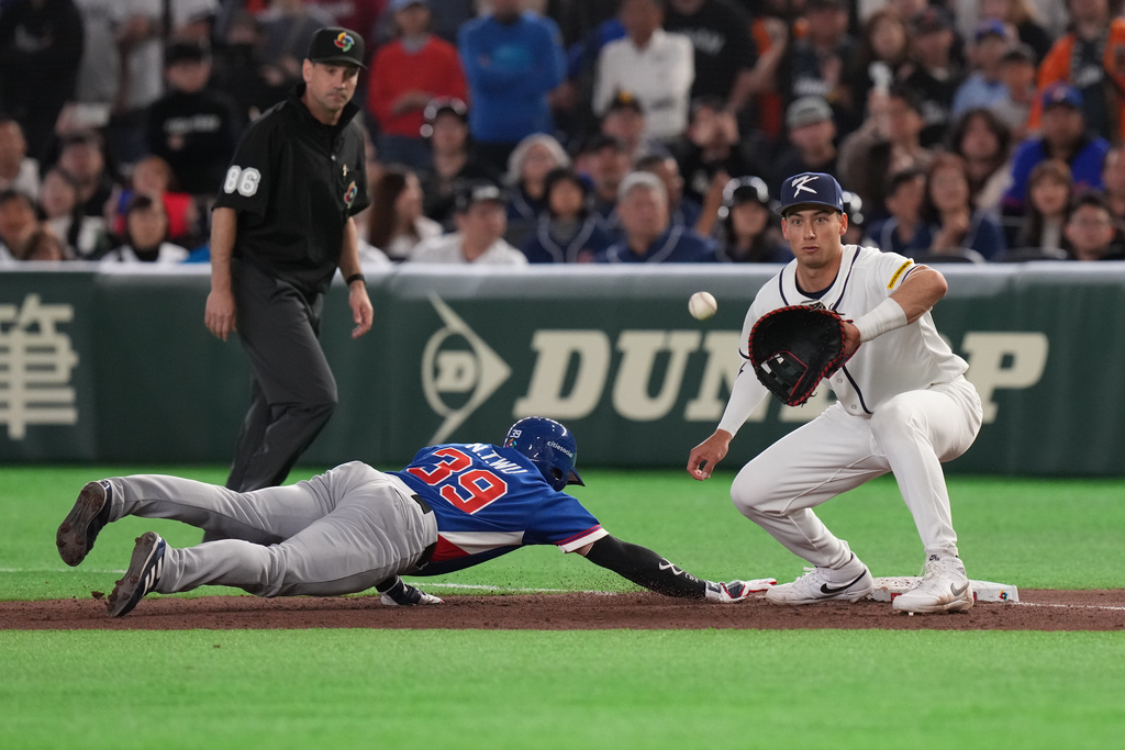 Taiwan's Wu Nien-ting slides into the first base as South Korea's Shay Whitcomb prepares to catch the ball during the seventh inning of a World Baseball Classic game between South Korea and Taiwan on Sunday, March 8, 2026 in Tokyo, Japan. (AP Photo/Eugene Hoshiko)