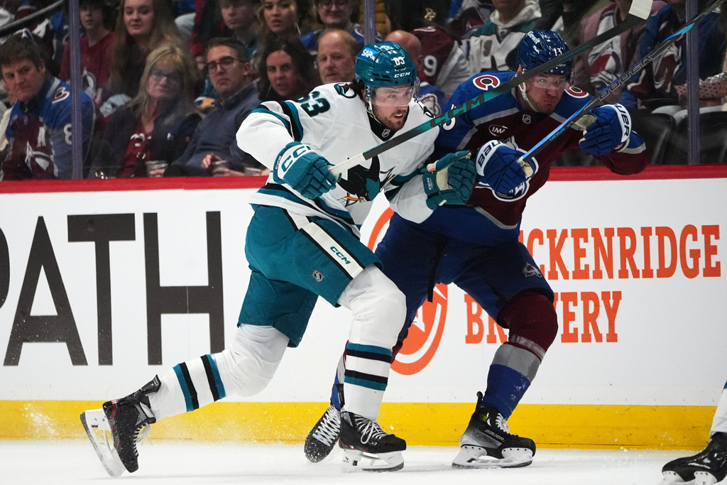 San Jose Sharks center Zack Ostapchuk, left, checks Colorado Avalanche right wing Valeri Nichushkin in the first period of an NHL hockey game, Wednesday, Feb. 4, 2026, in Denver. (AP Photo/David Zalubowski)