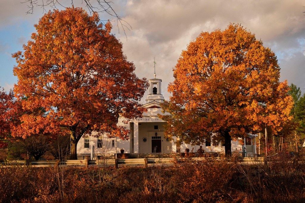 Town Hall stands behind a pair of colorful maple trees, Wednesday, Oct. 22, 2025, in Franconia, N.H. (AP Photo/Robert F. Bukaty)