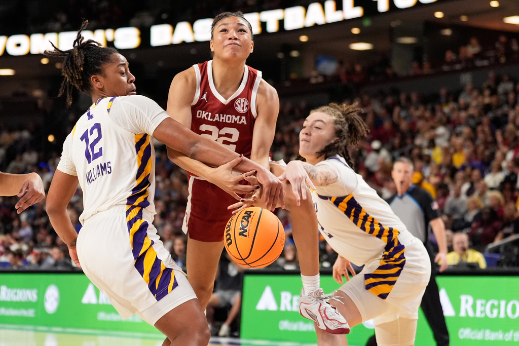Oklahoma guard Keziah Lofton (22) drives to the basket between LSU guard Mikaylah Williams (12) and forward Grace Knox during first half of an NCAA college basketball game in the quarterfinals of the Southeastern Conference tournament, Friday, March 6, 2026, in Greenville, S.C. (AP Photo/Chris Carlson)