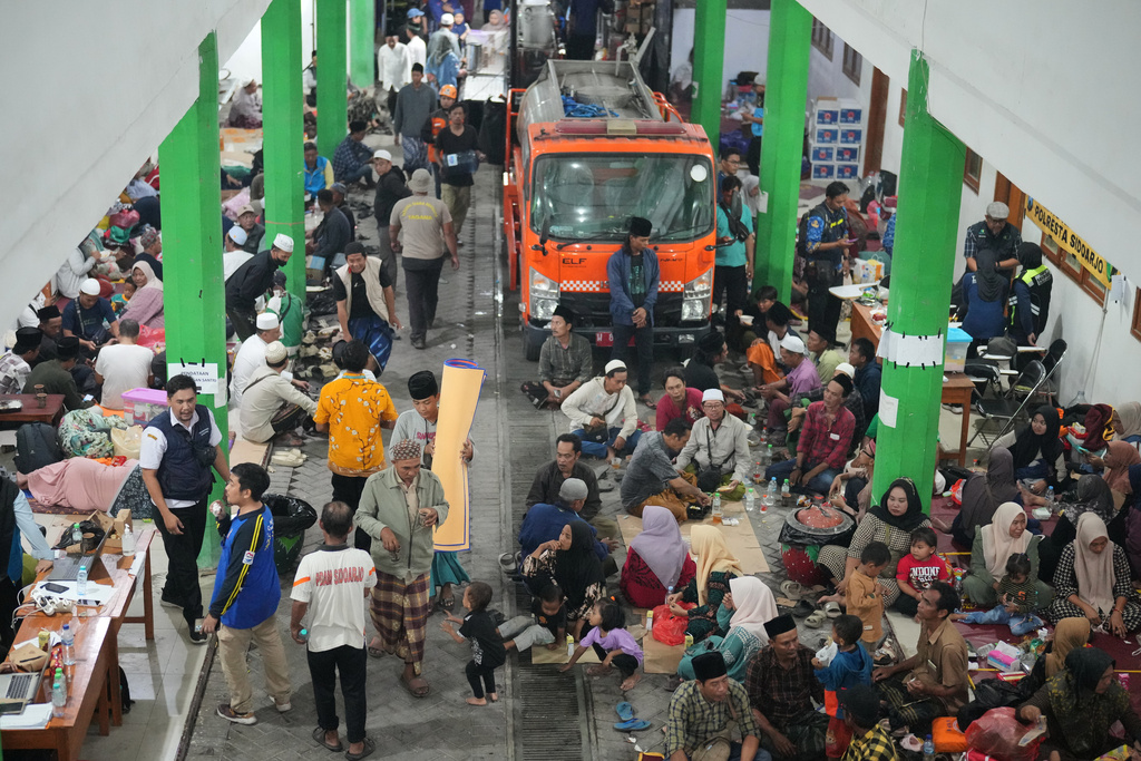 Family members of students wait in Sidoarjo, East Java, Indonesia, Wednesday, Oct. 1, 2025, as rescue works are underway for victims trapped under the rubble after a building under construction collapsed at an Islamic boarding school. (AP Photo/Achmad Ibrahim)