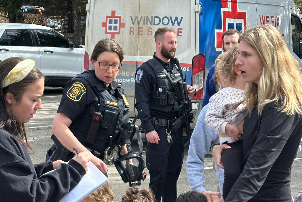 A woman gathers children as law enforcement respond to a call at Temple Israel synagogue on Thursday, March 12, 2026, in West Bloomfield Township, Mich. (AP Photo/Corey Williams)