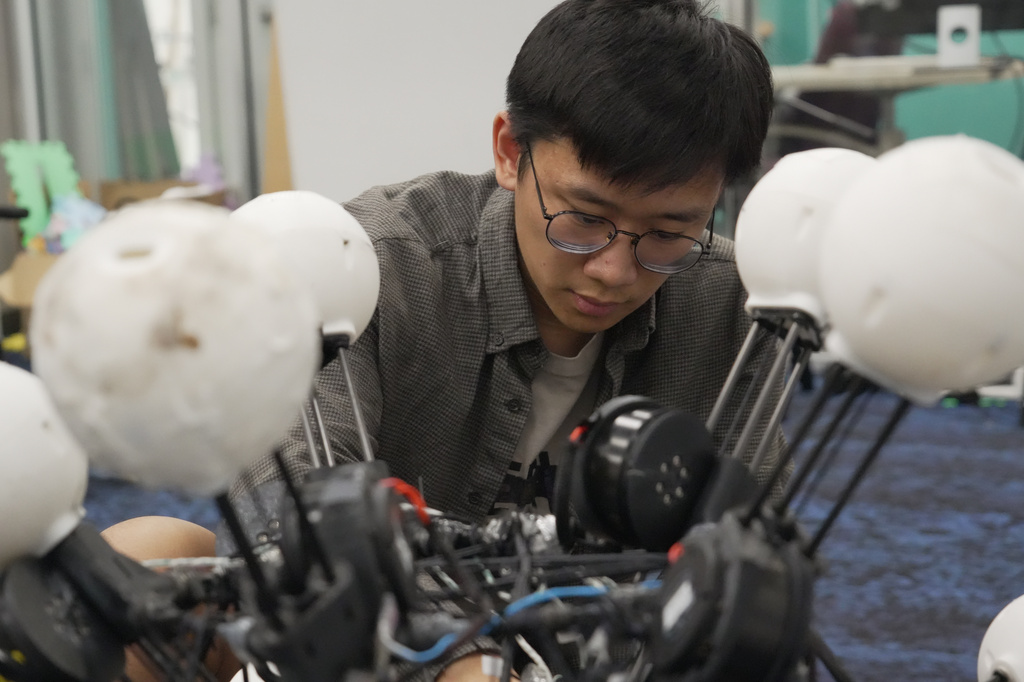 Jiaxun Liu, a Ph.D. student, works on a robot named Argus at Duke University's General Robotics Lab in Durham, N.C., Tuesday, May 26, 2026. (AP Photo/Allen G. Breed)