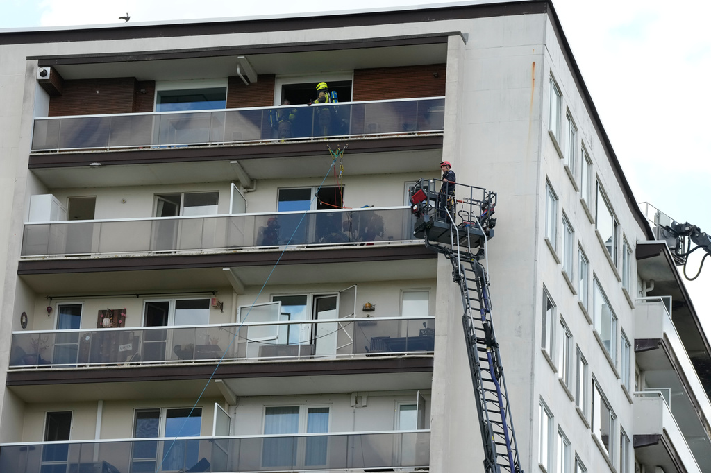 Rescue workers look for victims on upper floors after an apartment block fire in Linkeroever, Belgium, Wednesday, July 1, 2026. (AP Photo/Virginia Mayo)