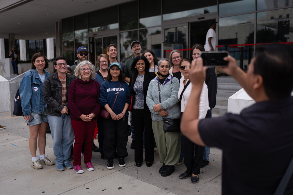 Masuma Khan, second from right in the front row, and her daughter, Riya, fourth from right in the front row, pose with supporters after an appointment at the federal building in Los Angeles, April 21, 2026. (AP Photo/Jae C. Hong)