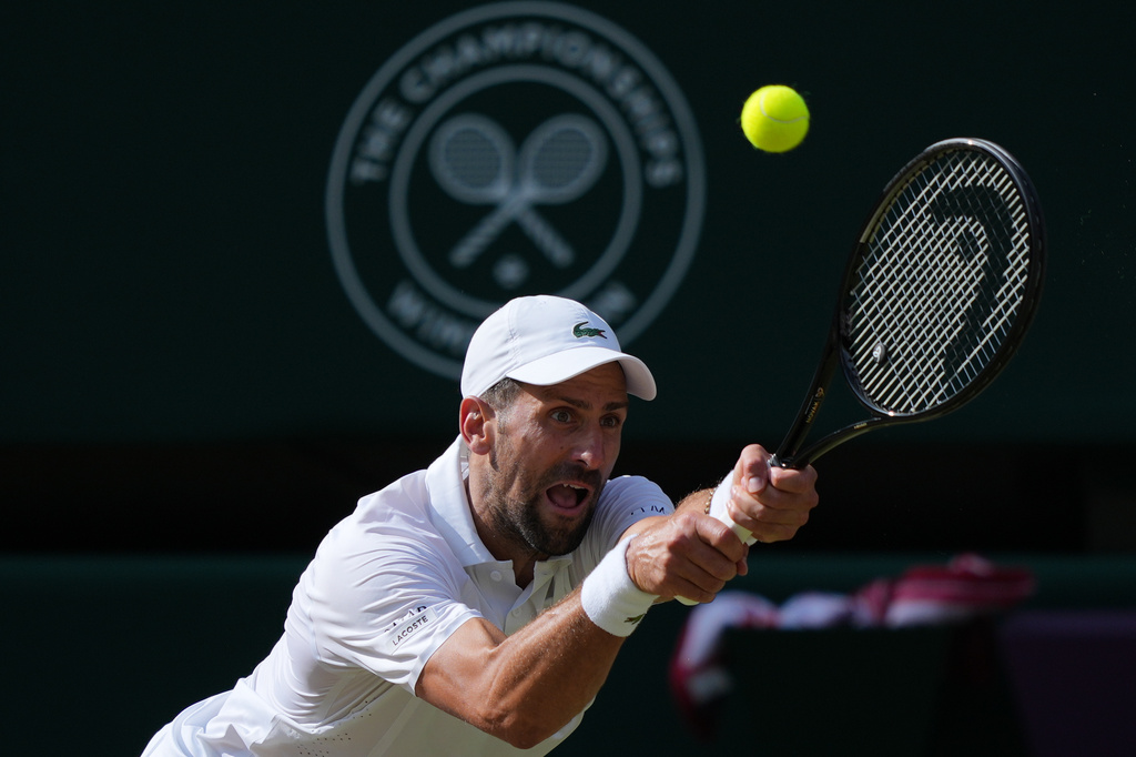 Novak Djokovic of Serbia returns the ball to Jannik Sinner of Italy in their men's singles semifinal match at the Wimbledon Tennis Championships in London, Friday, July 10, 2026. (AP Photo/Kin Cheung)
