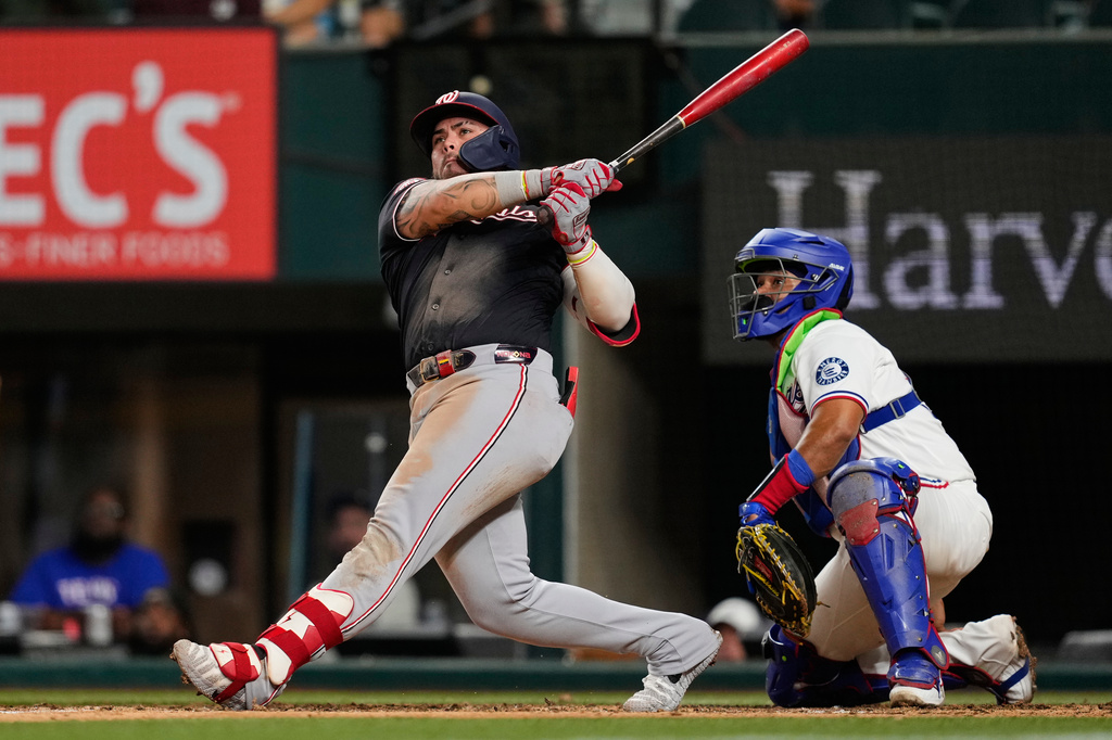 Washington Nationals' Andrés Chaparro follows through on a three-run home run as Texas Rangers catcher Elias Díaz looks on in seventh inning of a baseball game Wednesday, Aug. 19, 2026, in Arlington, Texas. (AP Photo/Tony Gutierrez)