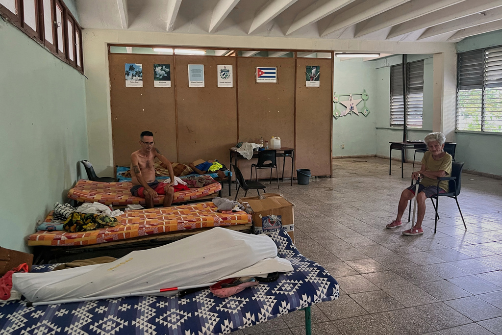 People displaced by Hurricane Melissa sit in a shelter in Los Mangos, Cuba, Monday, Nov. 17, 2025. (AP Photo/Milexsy Duran)