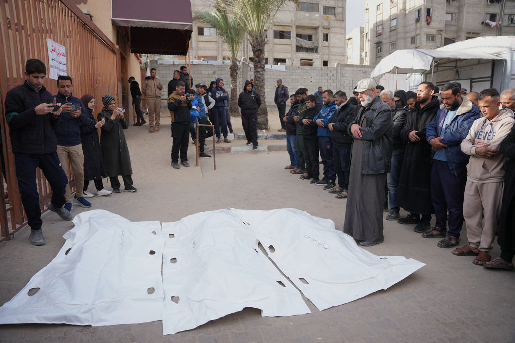 Palestinians mourn over the bodies of men who were killed in an Israeli military strike, during their funeral at Nasser Hospital in Khan Younis, Wednesday, Feb. 4, 2026. (AP Photo/Abdel Kareem Hana)