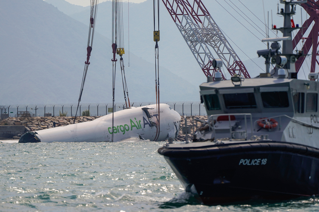 The wreckage of a cargo aircraft that skidded off a runway at the Hong Kong International Airport is prepared for removal on Sunday, Oct. 26, 2025. (AP Photo/Vernon Yuen)