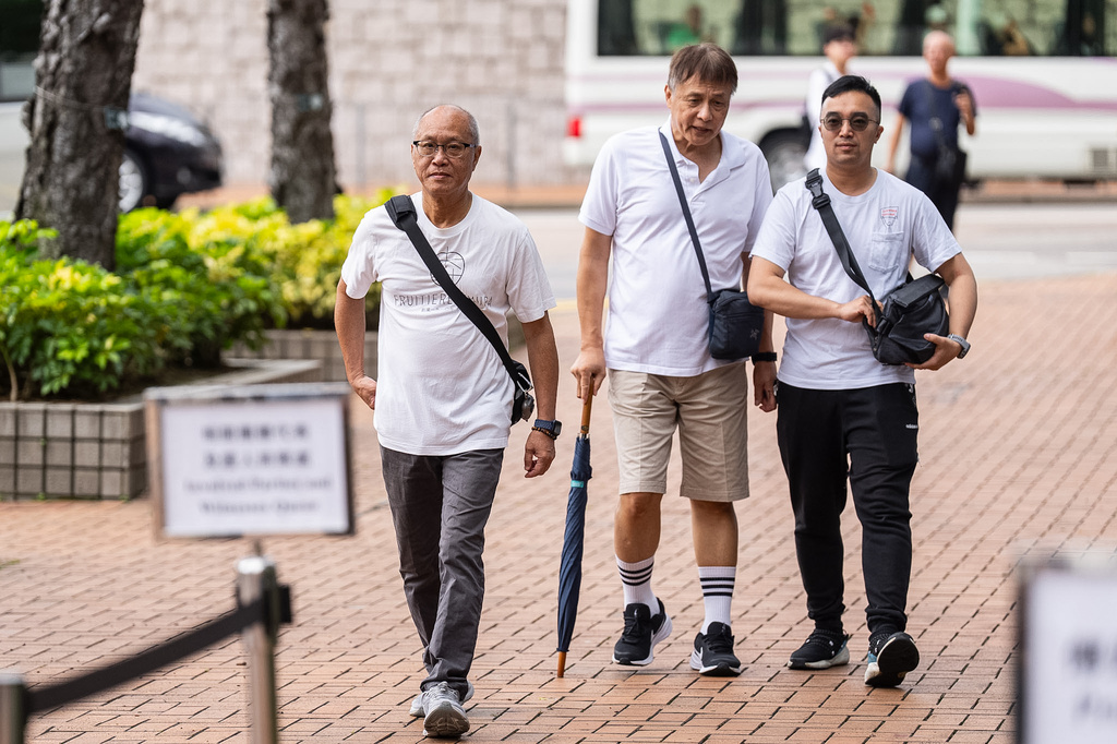 Yip Ka Kui, left, a family member of a victim of the last year's deadly fire, arrives for the independent committee hearing in Hong Kong, Wednesday, July 15, 2026. (AP Photo/Chan Long Hei)