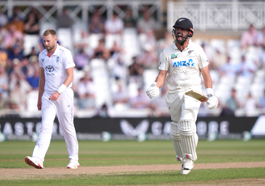 New Zealand's Daryl Mitchell, right, celebrates reaching a century on day four of the Third cricket Test between England and New Zealand in Nottingham, England, Sunday, June 28, 2026. (Joe Giddens/PA via AP)