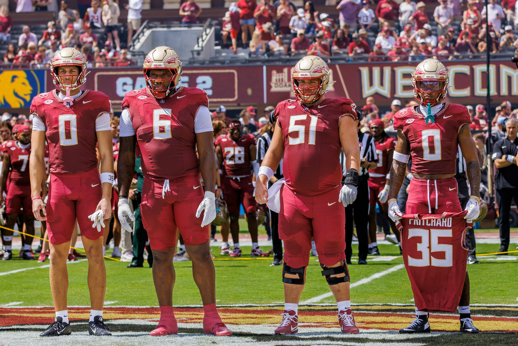 FILE - Florida State defensive back Earl Little Jr. (0) right, holds the jersey of linebacker Ethan Pritchard (35), as he is joined by Duce Robinson (0), Darrell Jackson Jr. (6), and Luke Petitbon (51) before the start of an NCAA college football game against East Texas A&M, Sept. 6, 2025, in Tallahassee, Fla. (AP Photo/Colin Hackley, File)