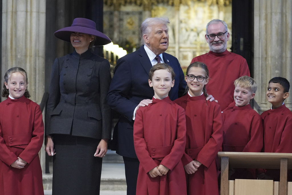 President Donald Trump and first lady Melania Trump pose with a childrens choir as they receive a tour of St. George's Chapel at Windsor Castle, Windsor, England, Wednesday, Sept. 17, 2025. (AP Photo/Evan Vucci, Pool)