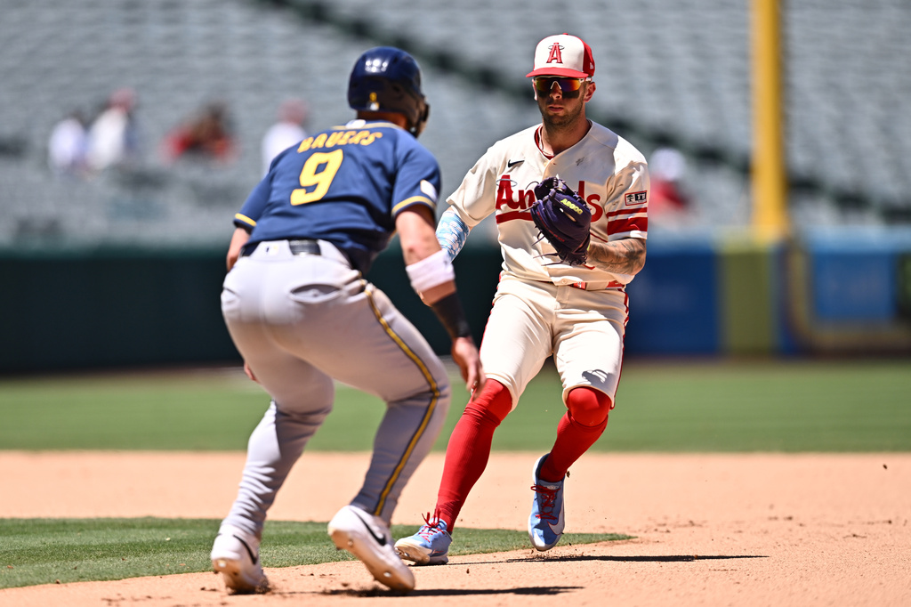 Los Angeles Angels shortstop Zach Neto, right, runs down Milwaukee Brewers' Jake Bauers (9) during the seventh inning of a baseball game Sunday, Aug. 2, 2026, in Anaheim, Calif. (AP Photo/William Liang)