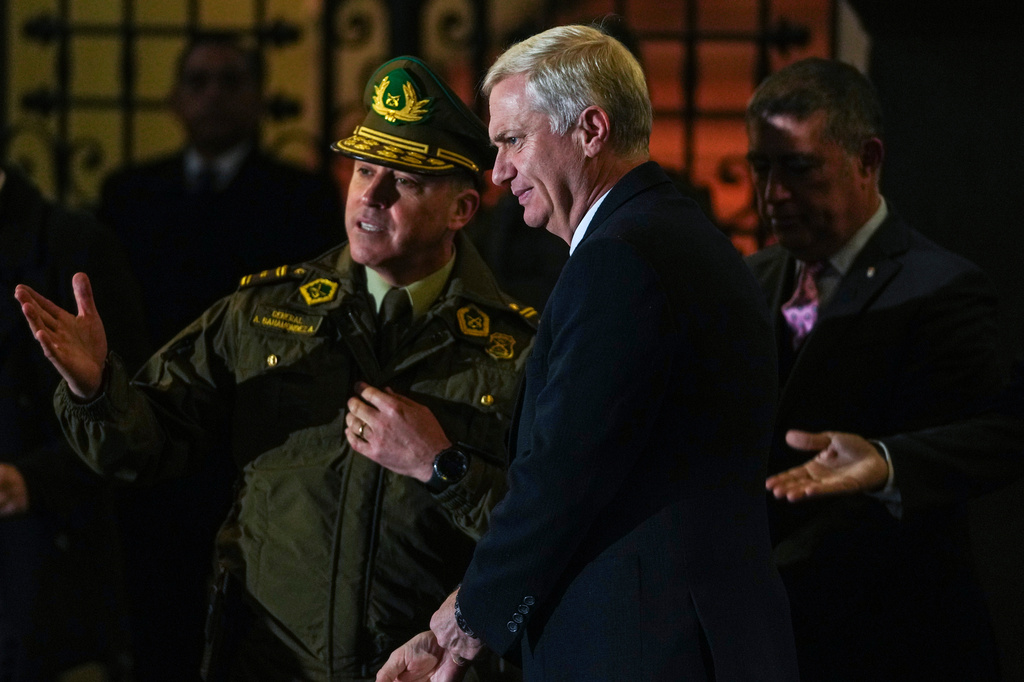 Chilean President José Antonio Kast visits with police officers after announcing a new security agenda and stricter immigration enforcement, at the Plaza de Armas in Santiago, Chile, Thursday, Aug. 6, 2026. (AP Photo/Esteban Felix)