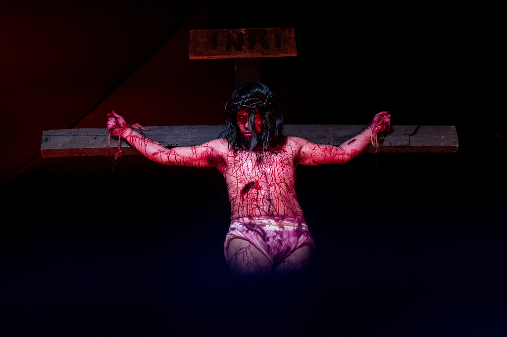 Luiz Henrique, playing the role of Jesus Christ, hangs on a cross during a Way of the Cross reenactment as part of Holy Week celebrations, at the Complexo do Alemao favela in Rio de Janeiro, Brazil, on Good Friday, April 3, 2026. (AP Photo/Bruna Prado)