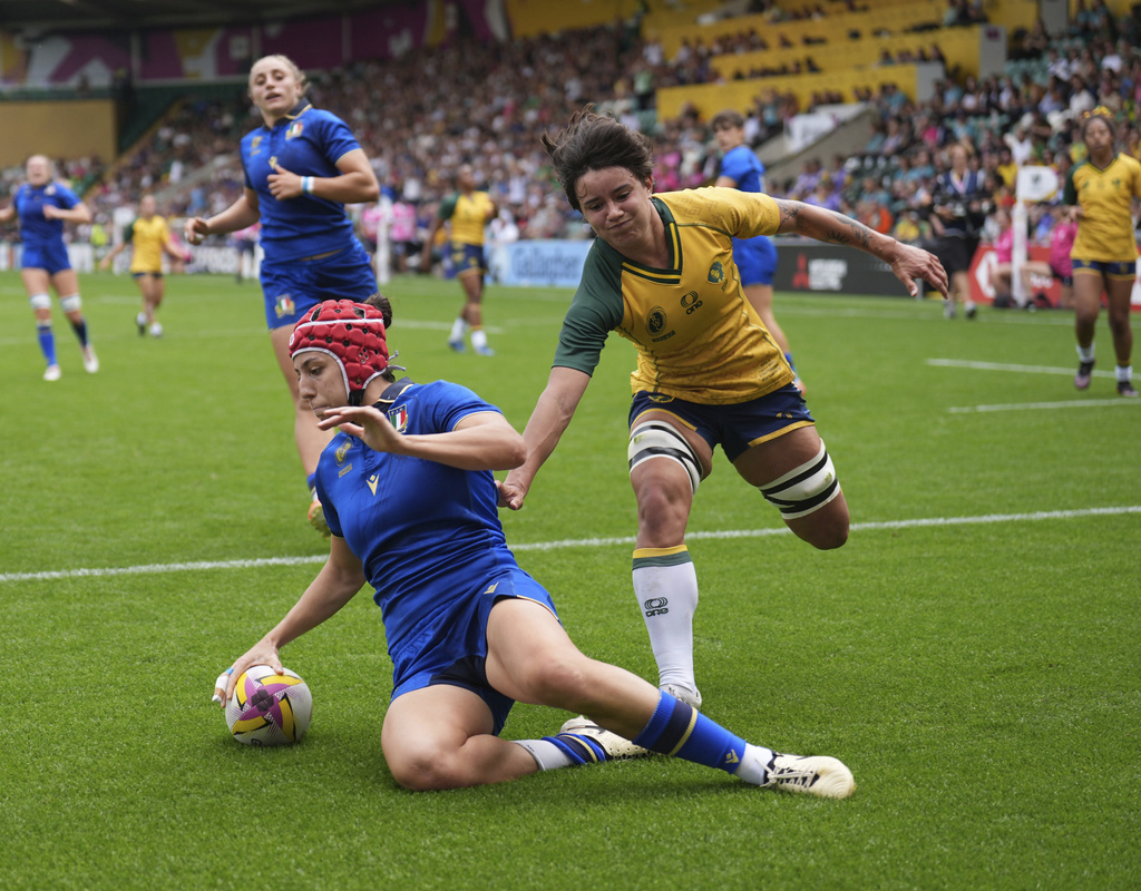 Italy's Vittoria Ostuni Minuzzi, left, scores her side's fourth try during the Women's Rugby World Cup 2025 pool D match between Italy and Brazil in Northampton, England, Sunday Sept. 7, 2025. (Joe Giddens/PA via AP)