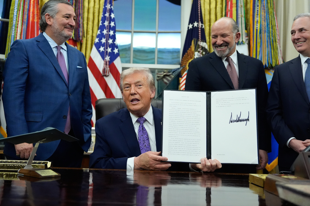 FILE - Flanked by Sen. Ted Cruz, R-Texas, left, Secretary of Commerce Howard Lutnick, second right, and White House AI and Crypto Czar David Sacks, President Donald Trump displays his signed AI initiative in the Oval Office of the White House, Dec. 11, 2025, in Washington. (AP Photo/Alex Brandon, File)