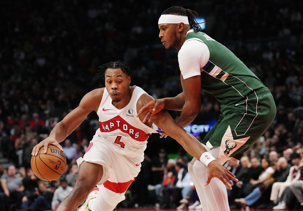 Toronto Raptors' Scottie Barnes (4) drives past Milwaukee Bucks' Myles Turner (3) during first half NBA basketball action in Toronto on Tuesday, Nov. 4, 2025. (Nathan Denette/The Canadian Press via AP)