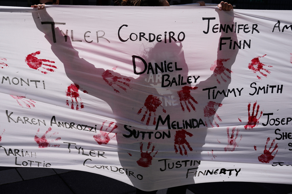 People hold a sign with the names of victims of the opioid crisis while rallying outside of a courthouse in Newark, N.J., Tuesday, April 21, 2026. (AP Photo/Seth Wenig)