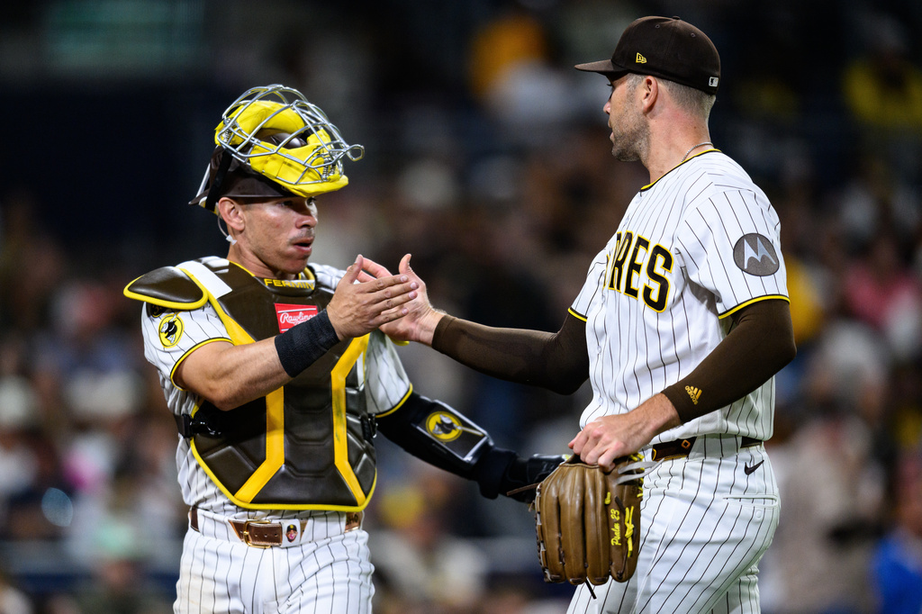 San Diego Padres pitcher Jason Adam, right, is greeted by catcher Freddy Fermin after striking out Athletics' Tyler Soderstrom during the eighth inning of a baseball game Saturday, May 23, 2026, in San Diego. (AP Photo/William Liang)