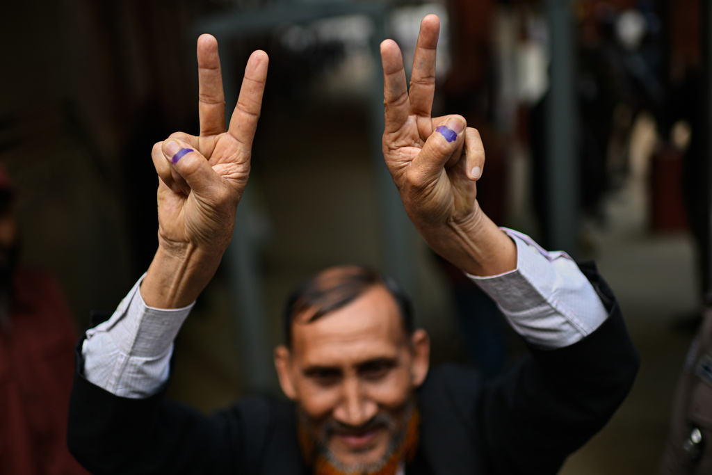 A person shows victory signs after casting his vote outside a polling center during the national parliamentary elections in Dhaka, Bangladesh, Thursday, Feb. 12, 2026. (AP Photo/Mahmud Hossain Opu)