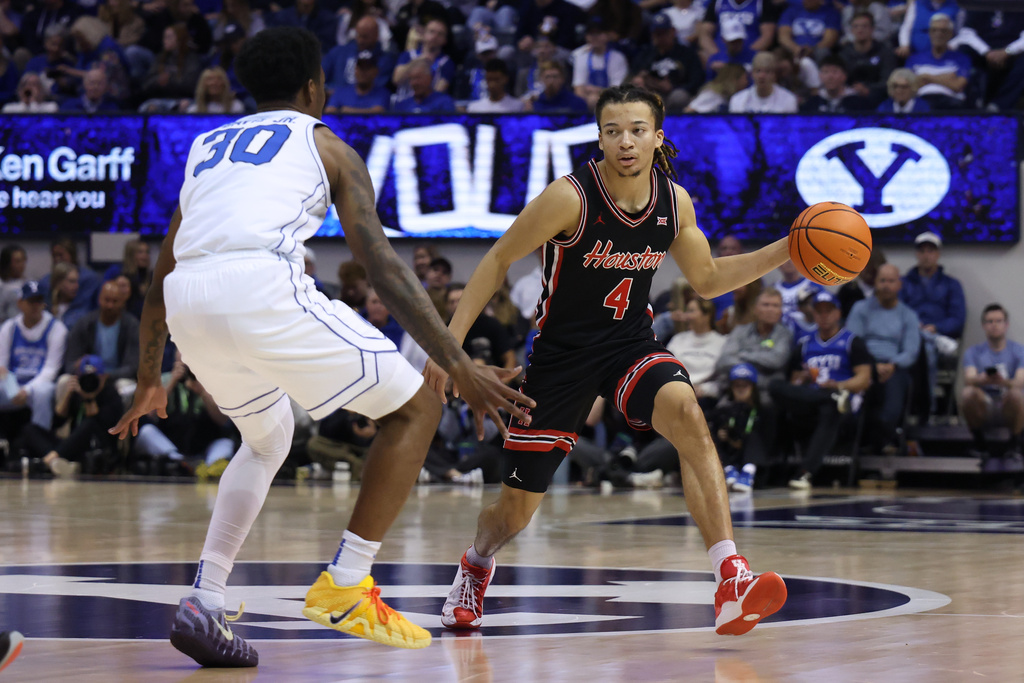 Houston guard Kingston Flemings (4) brings the ball up the court against BYU guard Kennard Davis Jr. (30) during the second half of an NCAA college basketball game, Saturday, Feb. 7, 2026, in Provo, Utah. (AP Photo/Rob Gray)