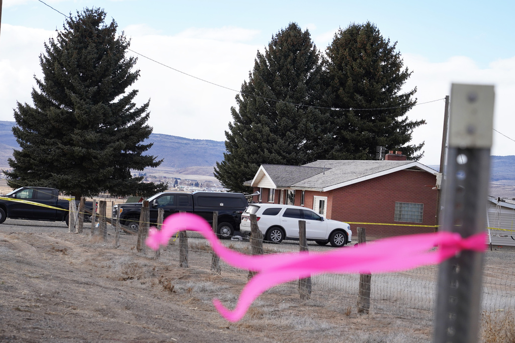 A pink ribbons hangs on a pole Thursday, March 5, 2026, in Lyman, Utah, in front of the house of a woman that was killed a day earlier. (AP Photo/George Frey)