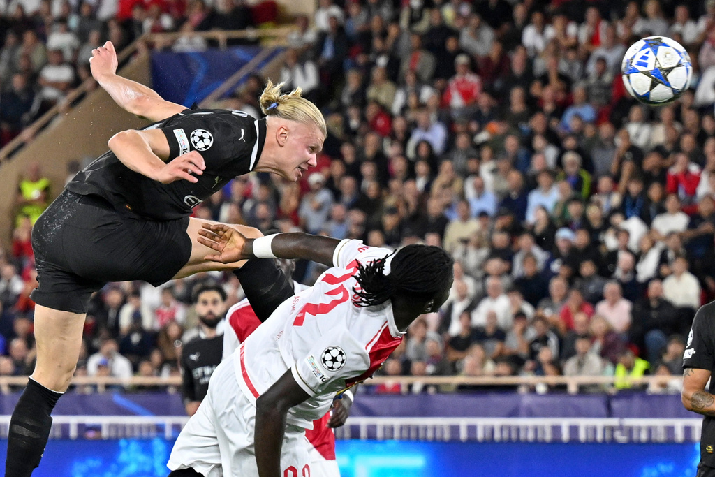 Manchester City's Erling Haaland, top, scores his side's second goal during the Champions League opening phase soccer match between Monaco and Manchester City at the Louis II stadium in Monaco, Wednesday, Oct. 1, 2025. (AP Photo/Philippe Magoni)