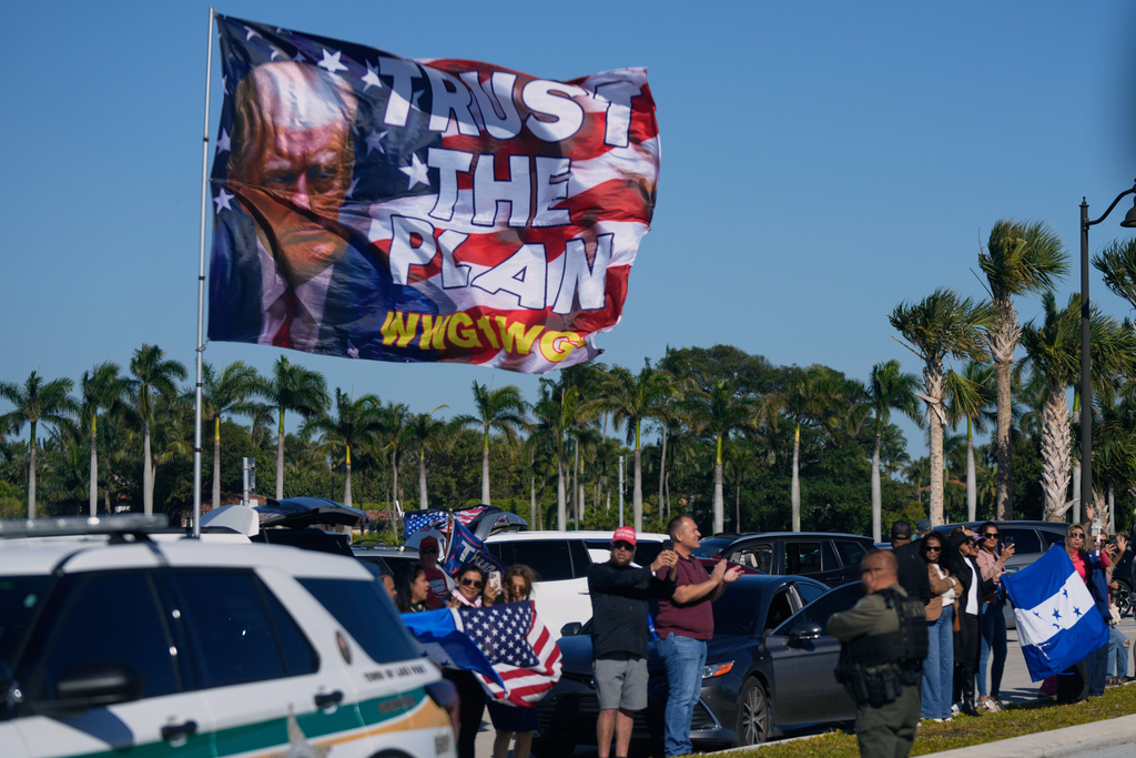 Supporters wave flags, including Honduran flags, as President Donald Trump's motorcade passes by on the way to his Mar-a-Lago club to meet with new Honduran President Nasry Asfura, Saturday, Feb. 7, 2026, in Palm Beach, Fla. (AP Photo/Mark Schiefelbein)