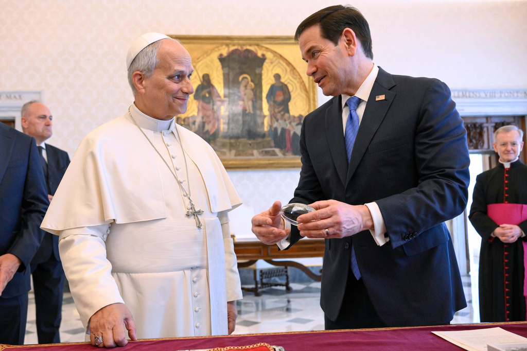 In this handout photo provided by Vatican Media Pope Leo XIV exchanges gifts with U.S. Secretary of State Marco Rubio, right, as they meet in the pope's private library at the Vatican, Thursday, May 7, 2026. (Vatican Media via AP)