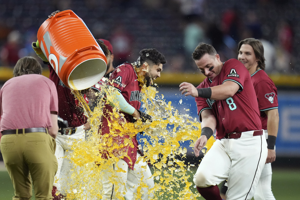 Arizona Diamondbacks' Adrian Del Castillo, left, gets hit with Gatorade as he celebrates his walk-off single against the Cleveland Guardians with Diamondbacks' James McCann (8) after a baseball game Wednesday, Aug. 20, 2025, in Phoenix. (AP Photo/Ross D. Franklin)