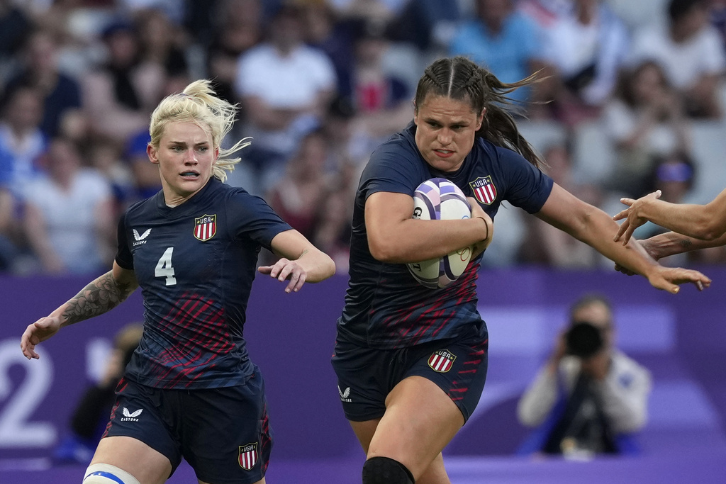 United States' Ilona Maher, fends off the tackle of Brazil's Gabriela Lima, right, during the women's Pool C Rugby Sevens match between the United States and Brazil at the 2024 Summer Olympics, in the Stade de France, in Saint-Denis, France, Sunday, July 28, 2024. (AP Photo/Tsvangirayi Mukwazhi)