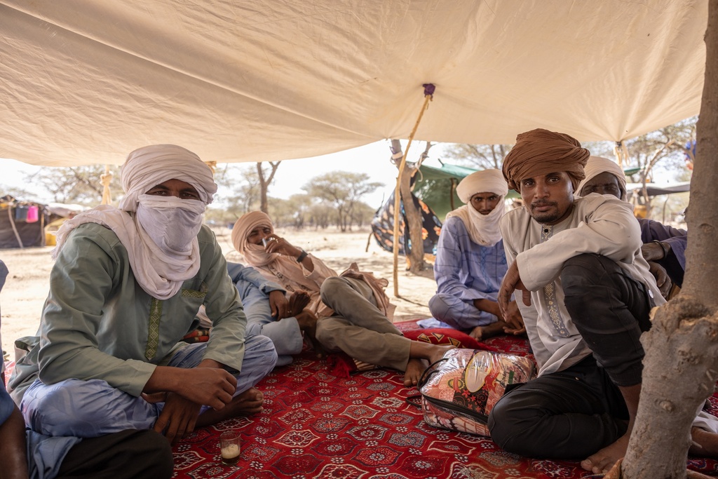 Men from northern Mali who fled attacks by the Malian Army and Africa Corps sit in a tent at a makeshift camp in Douankara, Mauritania, Saturday, Nov. 8, 2025. (AP Photo/Caitlin Kelly)