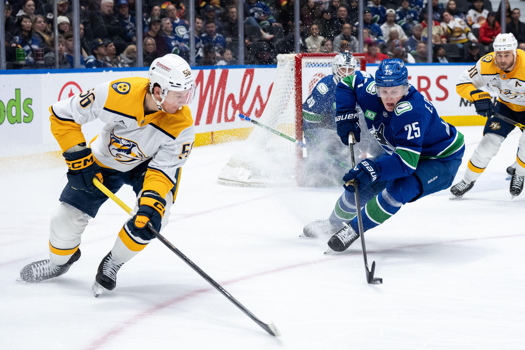 Vancouver Canucks' Elias Pettersson (25) skates with the puck as Nashville Predators' Erik Haula (56) watches during the second period of an NHL game in Vancouver, on Thursday, March 12, 2026. (Ethan Cairns/The Canadian Press via AP)