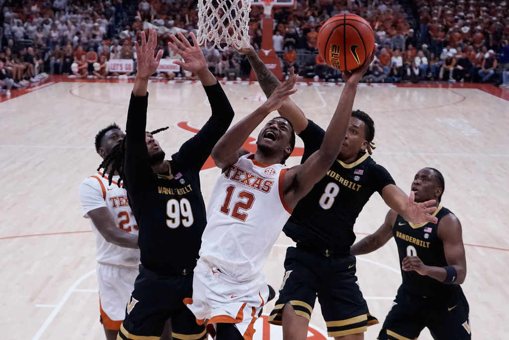 Texas guard Tramon Mark (12) drives to the basket against Vanderbilt forward Devin McGlockton (99) and forward Tyler Harris (8) during the second half of an NCAA college basketball game in Austin, Texas, Wednesday, Jan. 14, 2026. (AP Photo/Eric Gay)