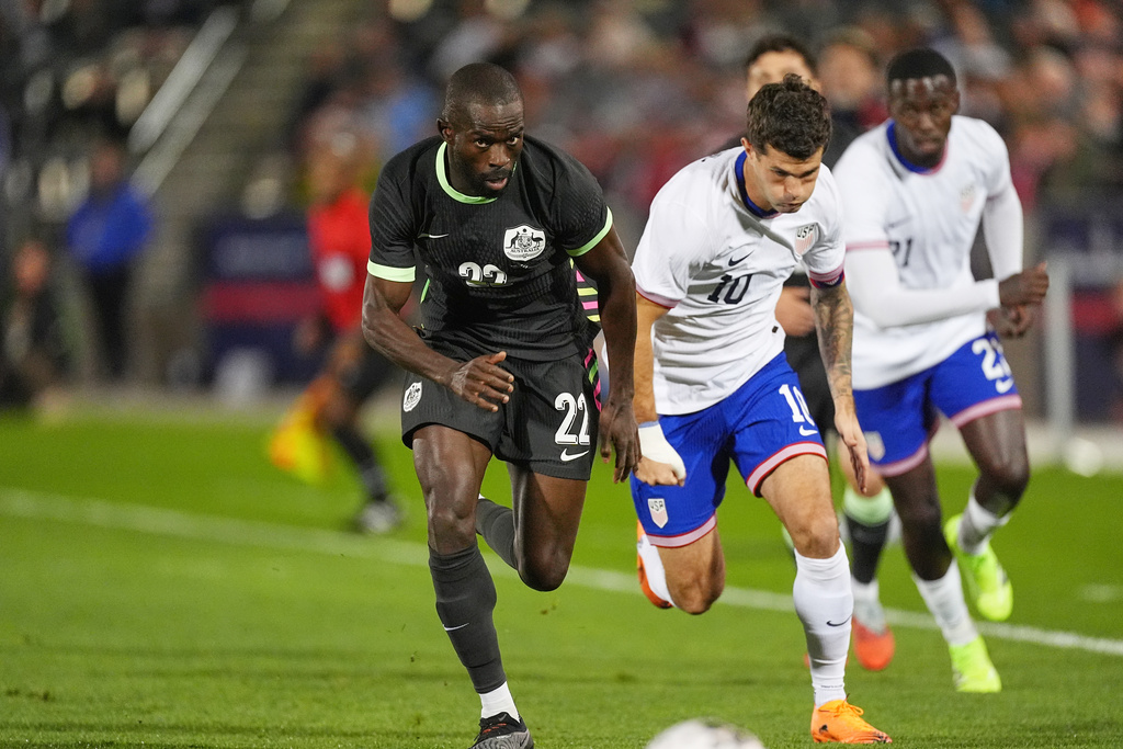 Australia's defender Jason Geria, left, pursues the ball with United States forward Christian Pulisic in the first half of an international friendly soccer match Tuesday, Oct. 14, 2025, in Commerce City, Colo.(AP Photo/David Zalubowski)