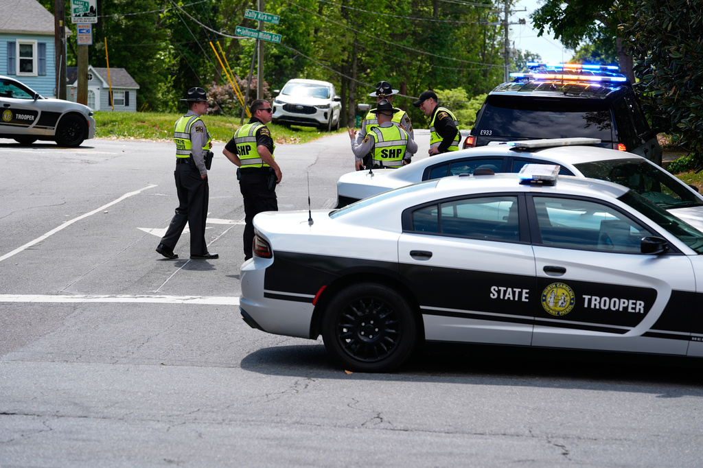 Law enforcement officers stand near the scene of a shooting at Leinbach Park on Monday, April 20, 2026, in Winston-Salem, N.C. (AP Photo/Erik Verduzco)