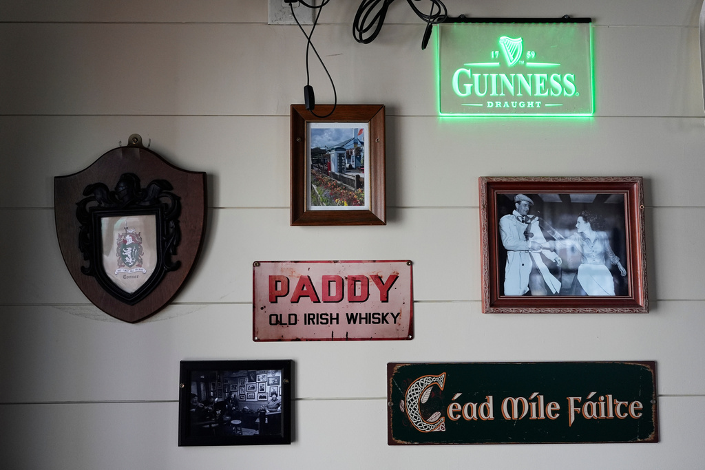 Irish signs and photos decorate a wall in a tiny pub, Wednesday, March 11, 2026, in Reading, Mass. (AP Photo/Robert F. Bukaty)