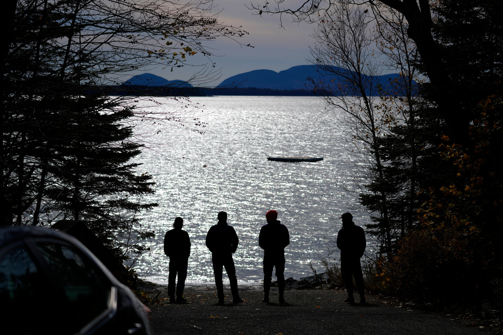 Graham Platner, Democratic candidate for U.S. Senate, third from left, and others, take in the view of Frenchman's Bay near his oyster farm, Monday, Nov. 3, 2025, in Sullivan, Maine. (AP Photo/Robert F. Bukaty)
