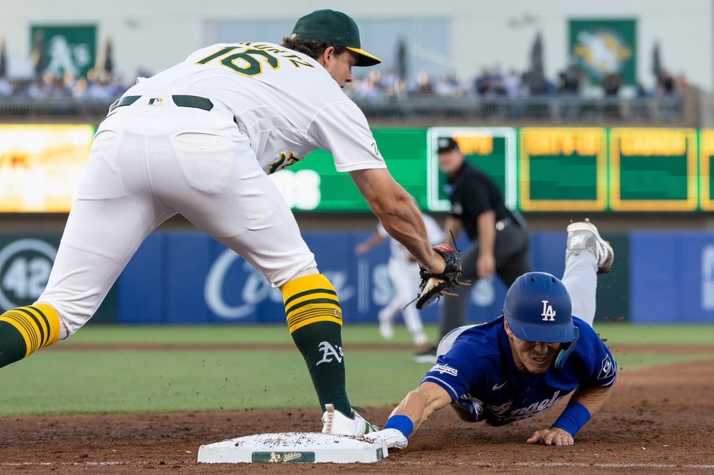 Athletics first baseman Nick Kurtz (16) picks off Los Angeles Dodgers' Tommy Edman during the fifth inning of a baseball game Tuesday, June 30, 2026, in West Sacramento, Calif. (AP Photo/Sara Nevis)