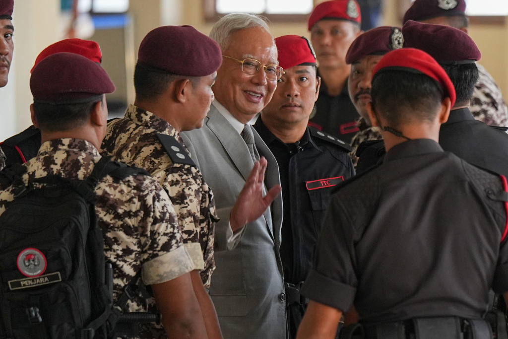 Former Malaysian Prime Minister Najib Razak, center, is escorted by prison officers on his arrival at the Kuala Lumpur High Court Complex, in Kuala Lumpur, Malaysia, Monday, Dec. 22, 2025. (AP Photo/Azneal Ishak)