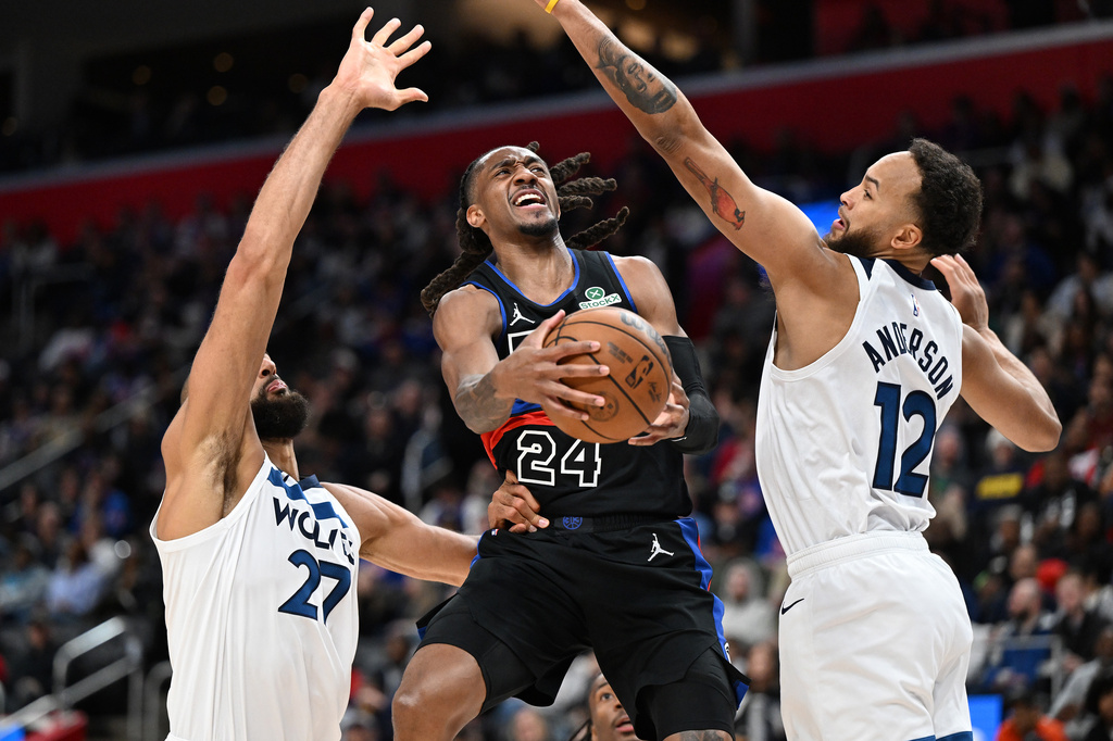 Detroit Pistons guard Daniss Jenkins (24) drives to the basket between Minnesota Timberwolves center Rudy Gobert (27) and forward Kyle Anderson (12) in the first half of an NBA basketball game Thursday, April 2, 2026, in Detroit. (AP Photo/Lon Horwedel)