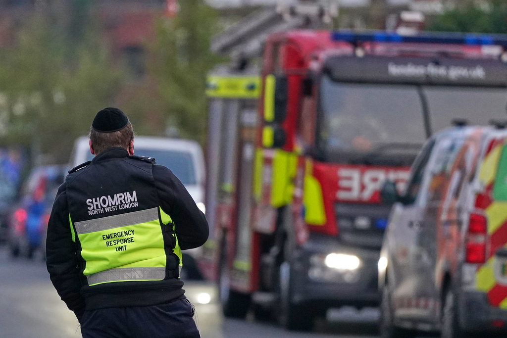 An officer from an emergency response unit watches a firefighter response team in London, Monday, March 23, 2026 after an apparent arson attack on four vehicles belonging to the Jewish ambulance service, Hatzola Northwest, in London.(AP Photo/Alberto Pezzali)