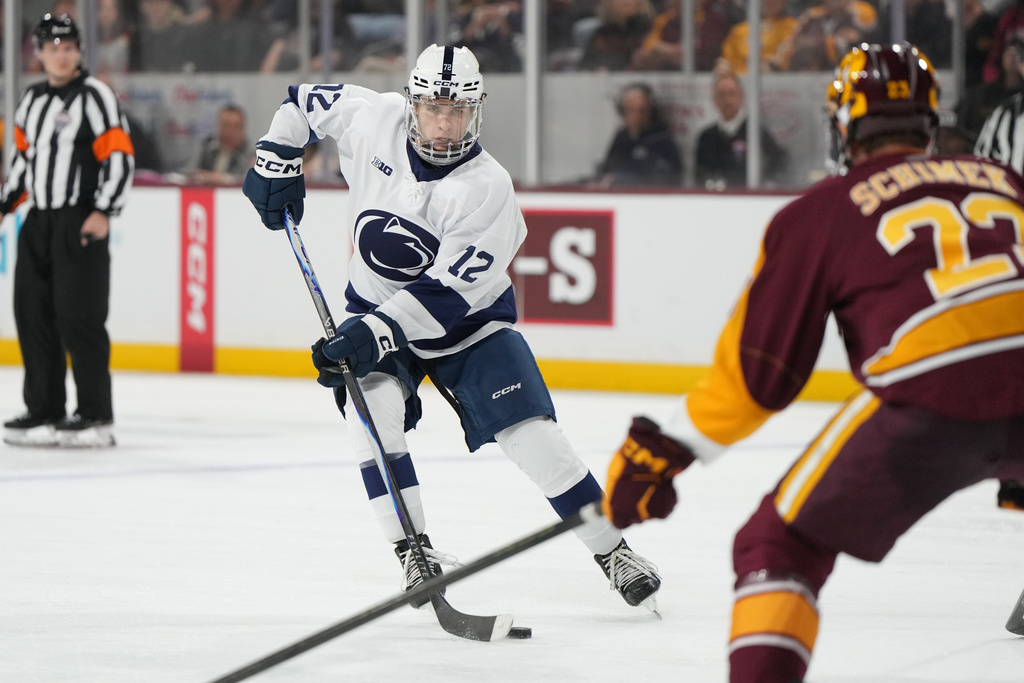 Penn State left winger Gavin McKenna, front left, carries the puck in front of Arizona State Bennett Schimek (23) during the second period of an NCAA college hockey game, Friday, Oct. 3, 2025, in Tempe, Ariz. (AP Photo/Rick Scuteri)